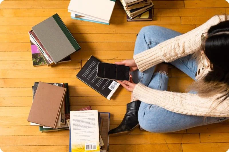 Person with books and phone
